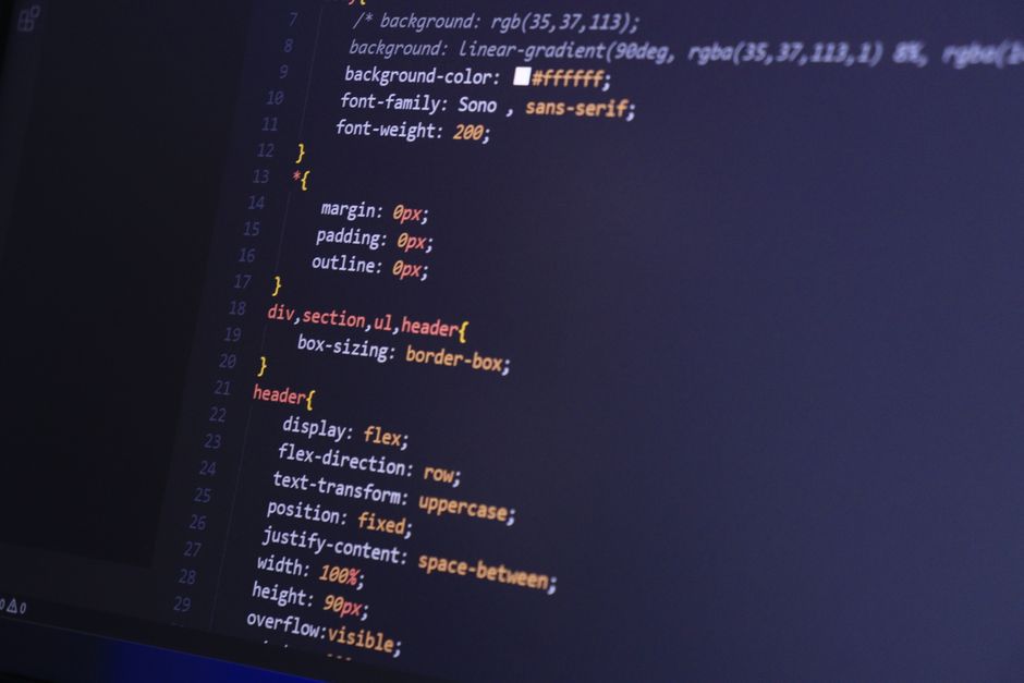 Laptop mit geöffnetem Code und Lernmaterial
